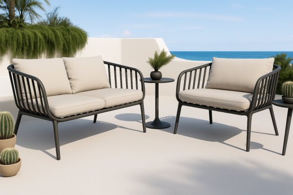 Sillón de exterior Banús de una plaza en color grafito con cojines beige sobre terraza con vistas al mar